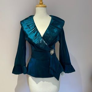 Beautiful teal ruffle top with brooch.